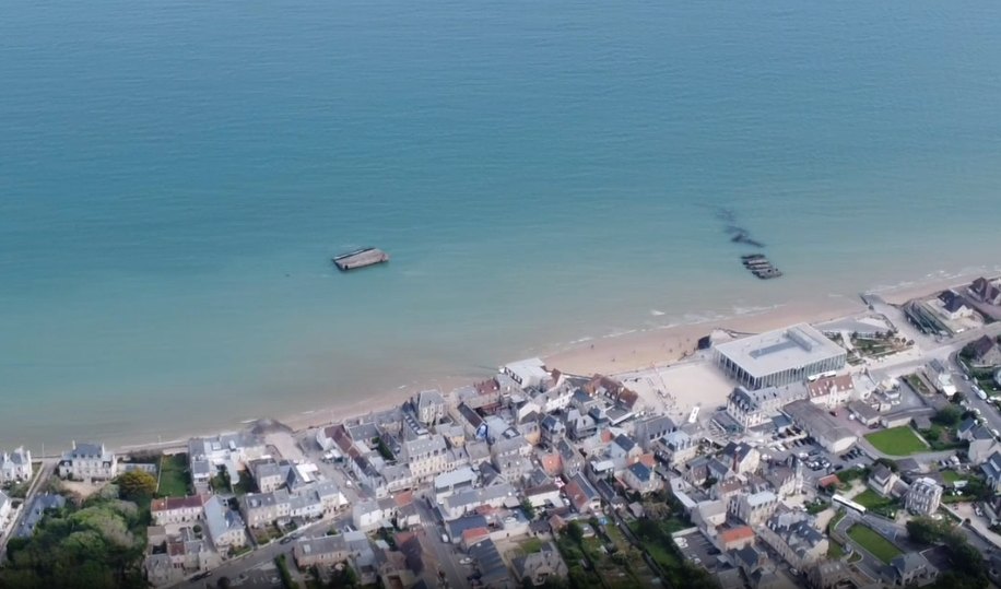 Vue aérienne d’Arromanches-les-Bains avec repères vers l’embarquement à Cale Neptune et le Musée du Débarquement.
